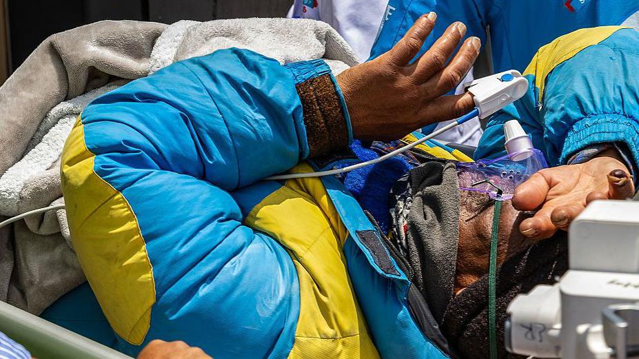 Dawa Sherpa en el momento en que es llevado en camilla al hospital de Katmandú