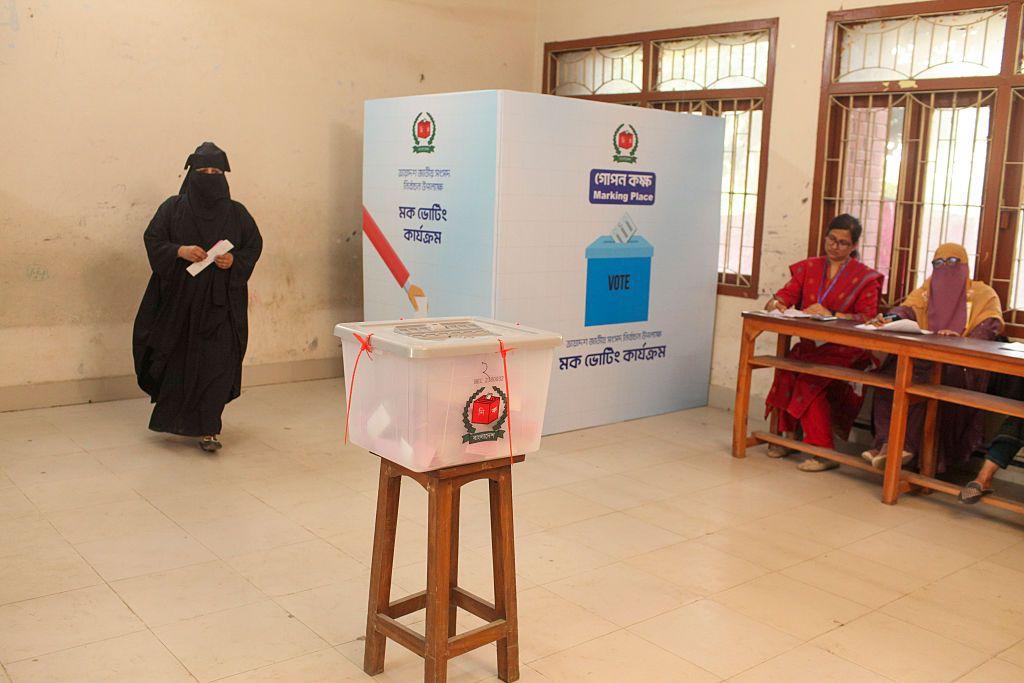 Uma mulher de burca &eacute; vista saindo de uma cabine de vota&ccedil;&atilde;o em Daca durante uma simula&ccedil;&atilde;o realizada pela Comiss&atilde;o Eleitoral de Bangladesh como parte dos preparativos para as pr&oacute;ximas elei&ccedil;&otilde;es nacionais