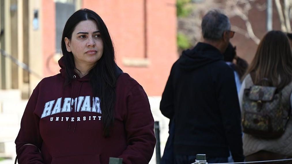 Una estudiante de Harvard viste una sudadera con el nombre de la universidad