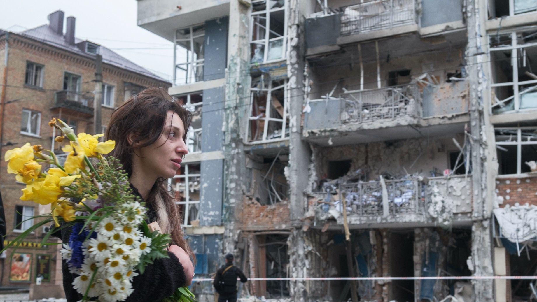 Zamrznuta ruska imovina: Šta hoće EU i zašto se Belgija protivi 3 Žena sa buketom cveća prolazi pored stambene zgrade u Ševčenkivskom okrugu Kijeva 25. maja 2025. Kosa joj je raščupana. Višespratna zgrada teško je oštećena u napadu ruskog drona