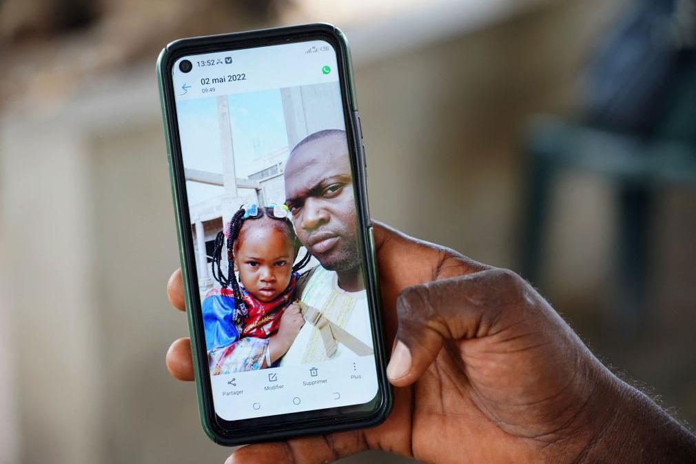 Wuri Bailo Keita, 33 anos, segura um celular mostrando uma foto dele e de sua falecida filha, Fatoumatta, que se acredita ter morrido de insuficiência renal aguda, em Banjul, em 10 de outubro de 2022. — Nos últimos 3 meses, 69 crianças morreram de insuficiência renal aguda, que se acredita ter sido causada por quatro xaropes para tosse fabricados pela empresa farmacêutica indiana Maiden Pharmaceuticals. As autoridades indianas estão investigando os xaropes fabricados pela empresa farmacêutica local após a Organização Mundial da Saúde afirmar que eles podem ser responsáveis pelas mortes das crianças na Gâmbia.