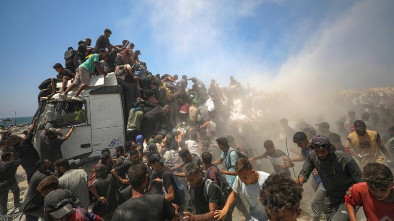Palestinos em Gaza tentam alcançar comida que chegou ao território neste dia 27 de julho