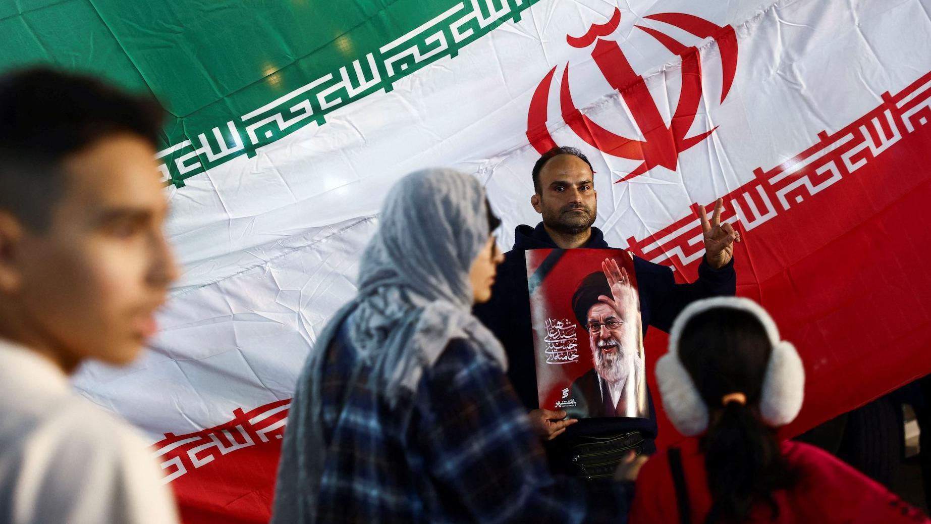 Čovek u Teheranu drži sliku ubijenog vrhovnog vođe Alija Hamneija