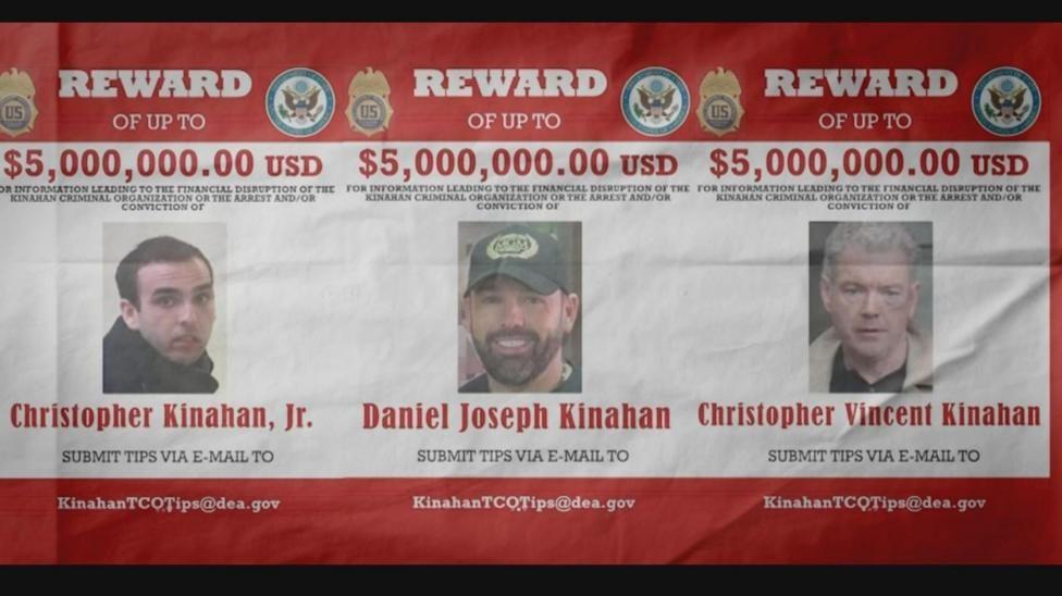 Un cartel de recompensa del FBI en rojo y blanco nombra a Christopher Jr., Christopher Vincent y Daniel Joseph Kinahan. Hay varias insignias y logotipos federales de EE. UU. Dice que ofrece una recompensa de US$5 millones por información sobre cada uno de los presuntos líderes del cartel de Kinahan.