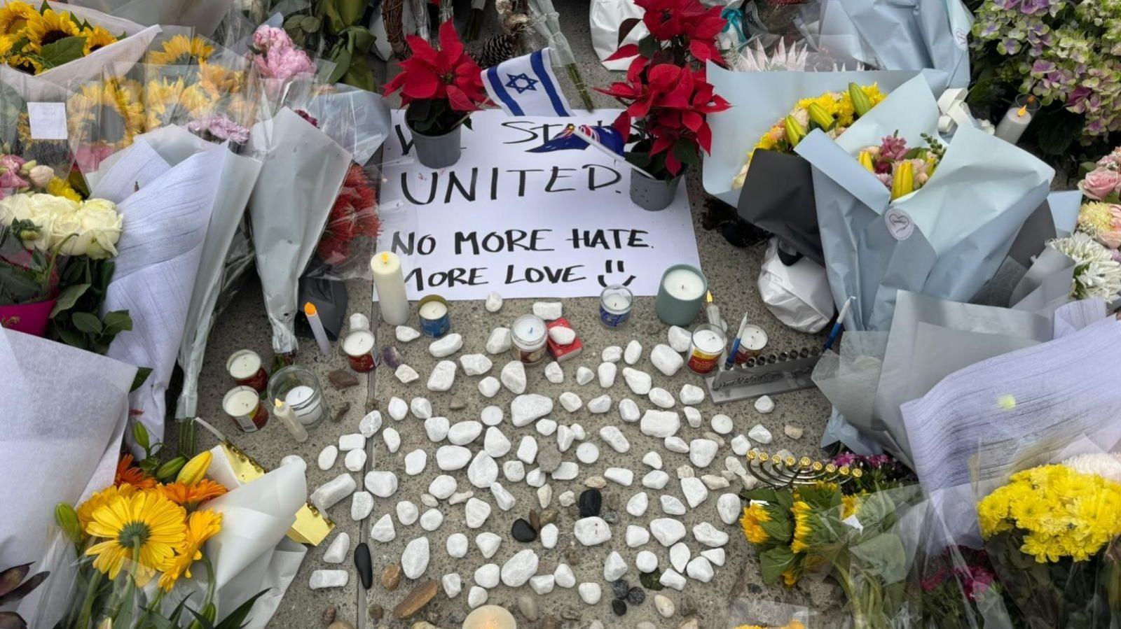 Ofrendas florales y un mensaje que lee: