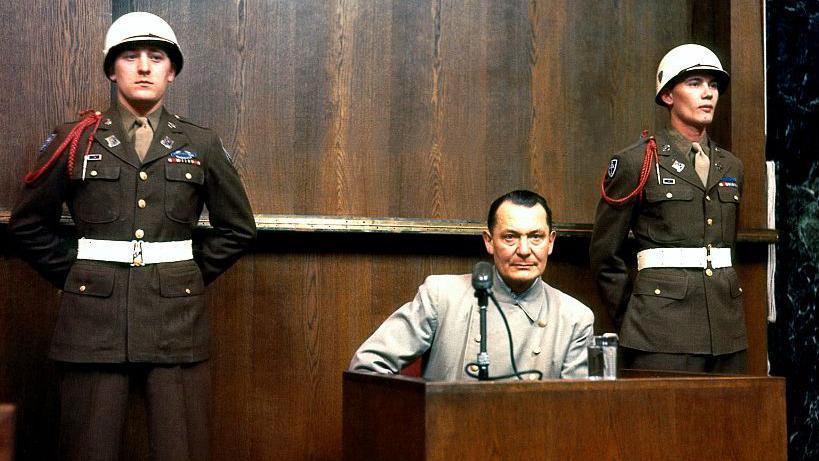 Goering durante una de sus declaraciones ante el Tribunal Militar Internacional custodiado por dos soldados.
