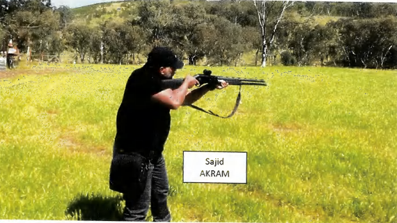 Un hombre vestido de negro apunta con un arma.