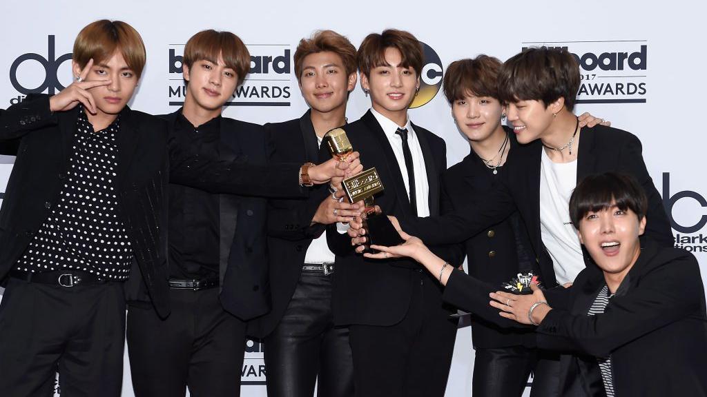 La banda BTS posa con un premio.