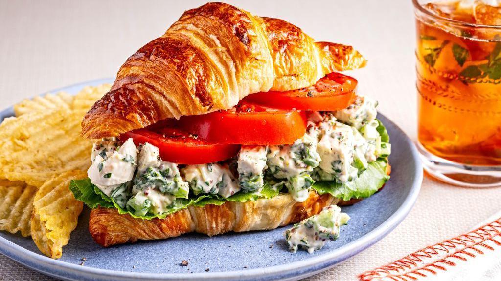 قطعة كرواسان في طبق محشوة بالجبنة والطماطم والخس