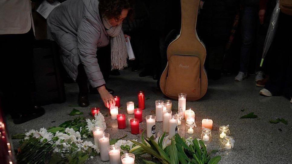 La gente coloca velas y flores mientras se reúne para una vigilia en honor a las víctimas del accidente de tren de alta velocidad del 18 de enero, que causó la muerte de 45 personas en Adamuz