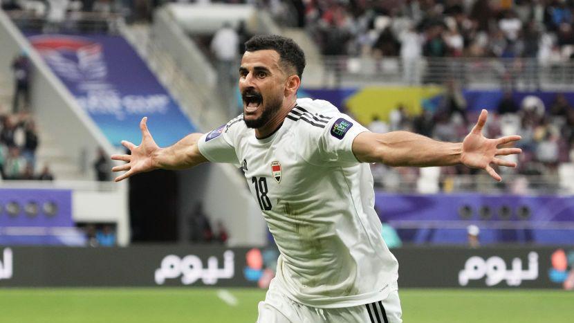 لاعب كرة قدم يحتفل فاتحاً بيديه بتسجيل هدف - قميص أبيض رسمي للمنتخب العراقي - المهاجم أيمن حسين