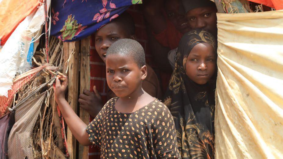 Cuatro muchachas se asoman a la entrada de una choza en el campo de refugiados de Baidoa, Somalia. 