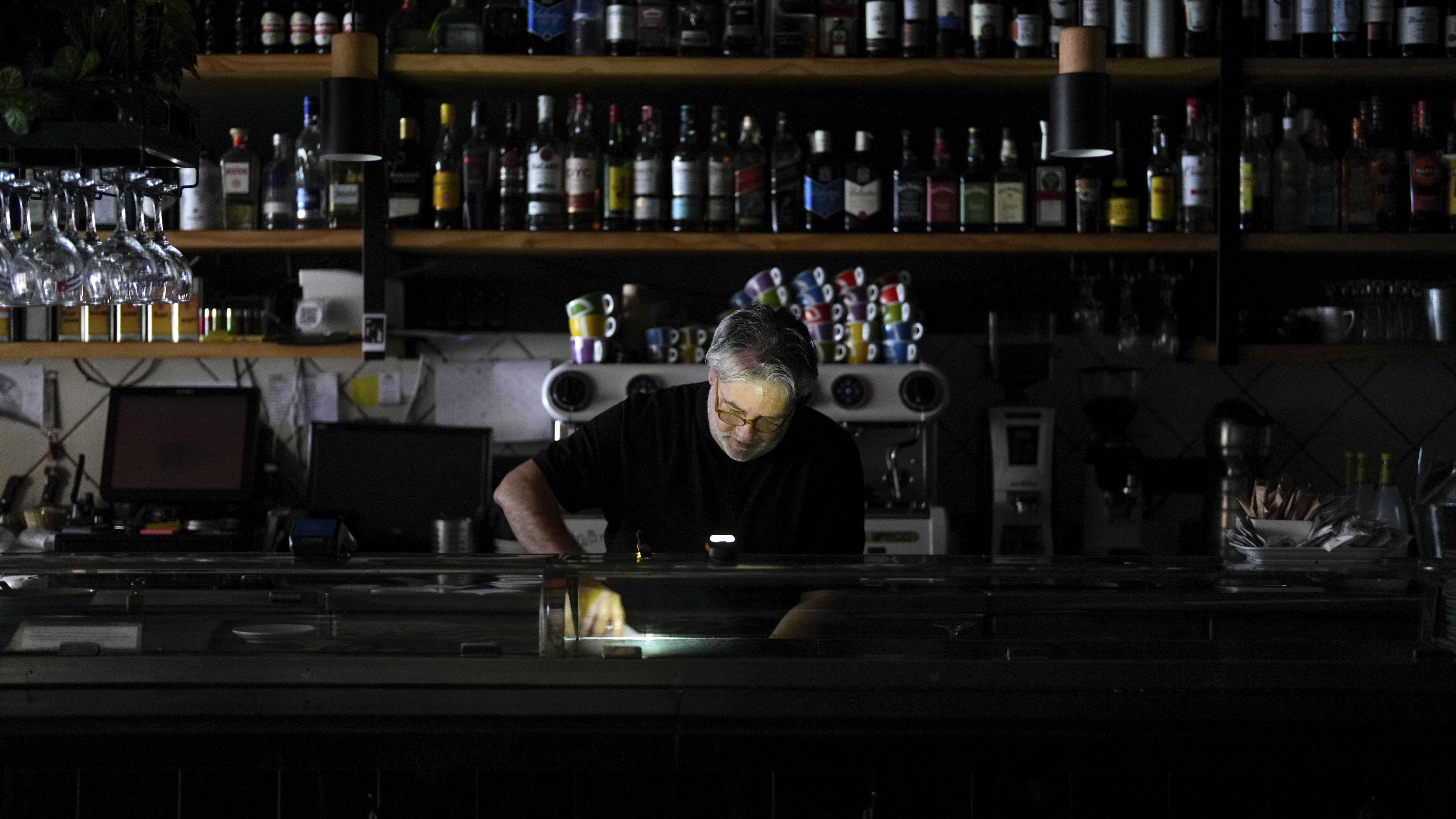 Homem trabalha em um restaurante no escuro em Madri. 