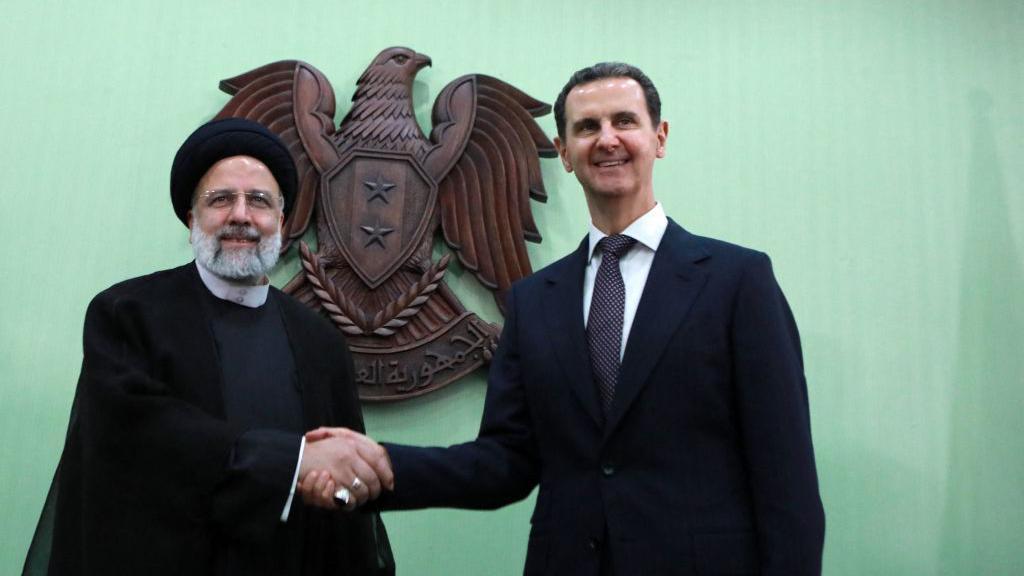 El presidente sirio, Bashar al-Assad (der.), estrecha la mano de su homólogo iraní, Ebrahim Raisi, en Damasco el 3 de mayo de 2023.