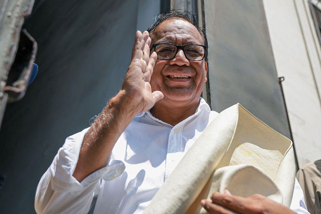 Roberto Sánchez saluda sonriente sujentando un sombrero con la mano izquierda. 