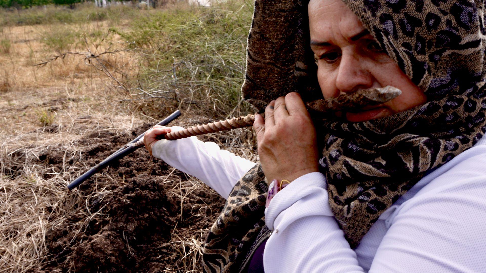 방금 땅에서 뽑아낸 금속 막대의 냄새를 맡는 레이날다 풀리도