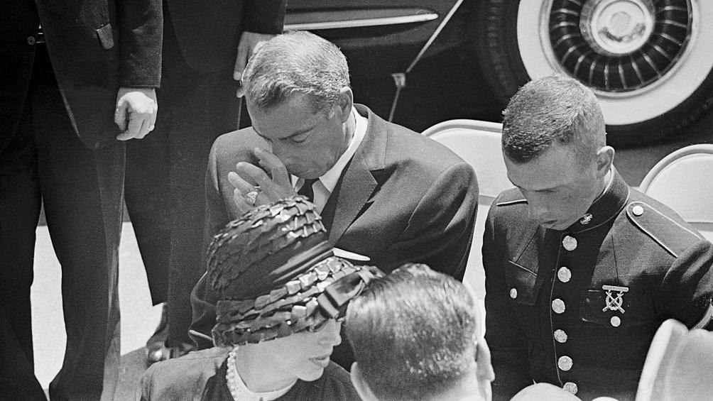 Joe DiMaggio cabizbajo, acompañado de su hijo, durante el funeral de Marilyn Monroe el 14 de agosto de 1962