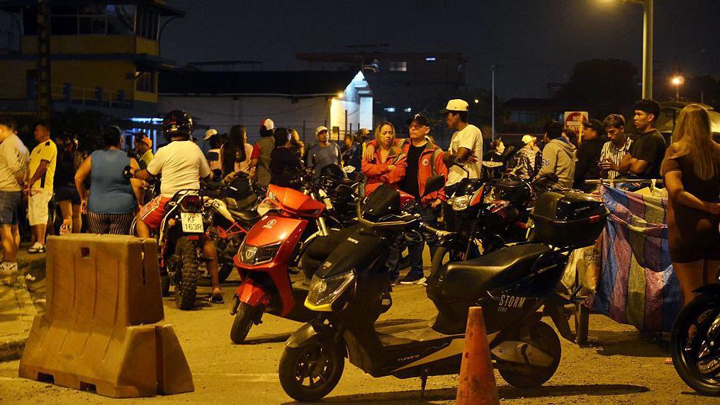 Personas en moto en la entrada de la prisión de Machala