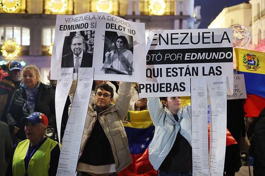 Los manifestantes sostienen carteles en apoyo del líder opositor venezolano Edmundo González Urrutia y en contra de la presidenta interina de Venezuela, Delcy Rodríguez, durante una manifestación para exigir libertad para Venezuela, tras la operación militar estadounidense en Venezuela para capturar al presidente venezolano, en Madrid el 4 de enero de 2026.