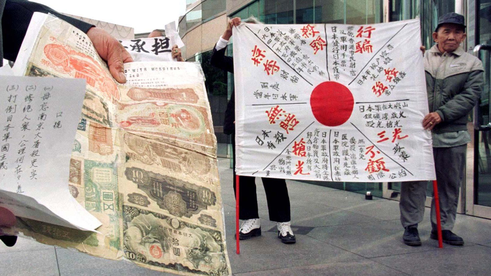 香港索償協會會員在日本駐香港總領事館所在的中環交易廣場外展示宣傳日軍佔領香港時所犯戰爭罪行的橫幅（11/12/1998）