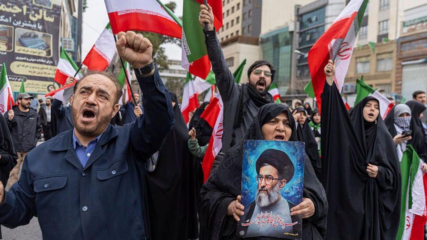 أشخاص يتظاهرون حاملين أعلاماً