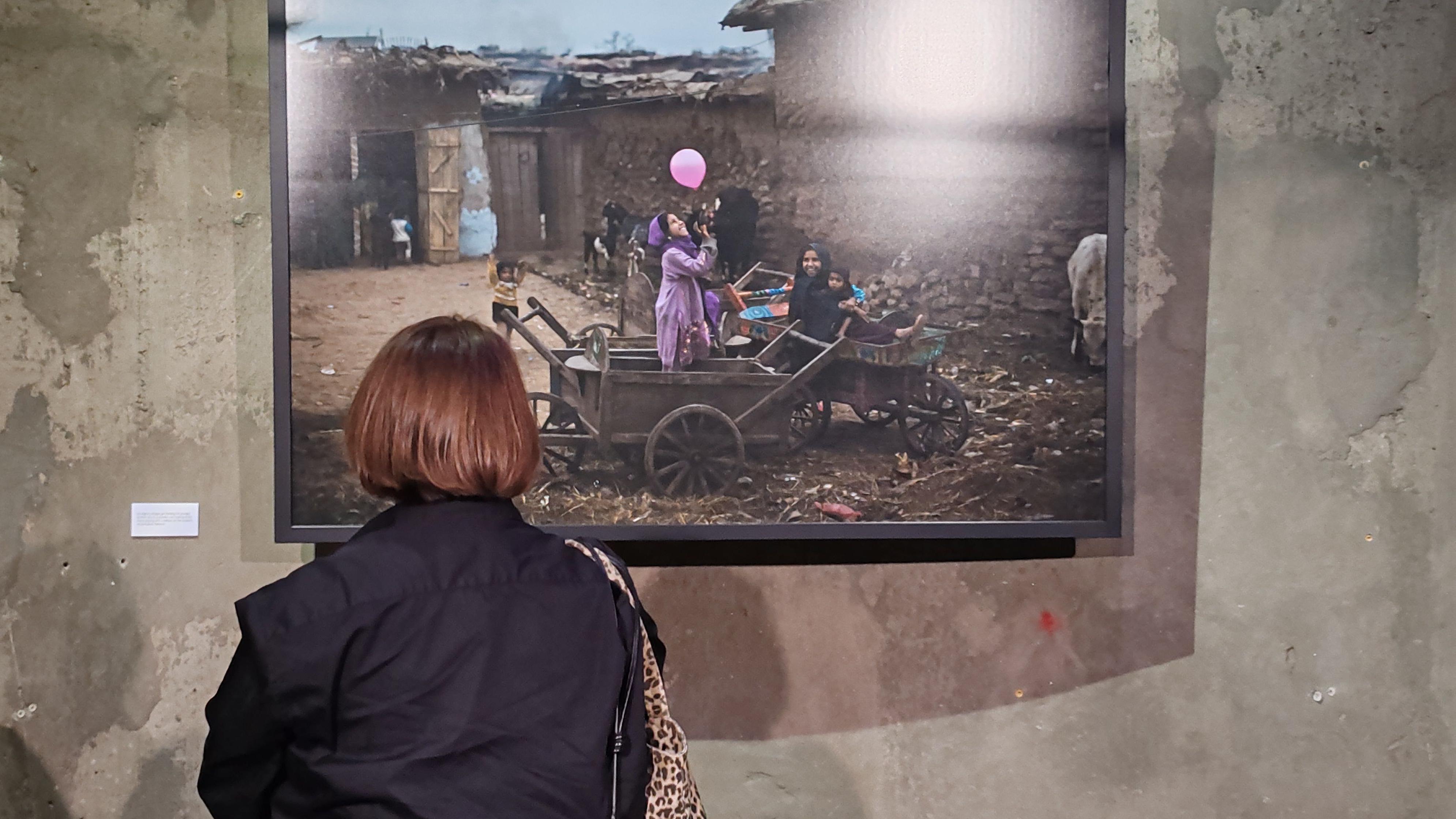 Žena gleda fotografiju dece koja s eigraju balonima