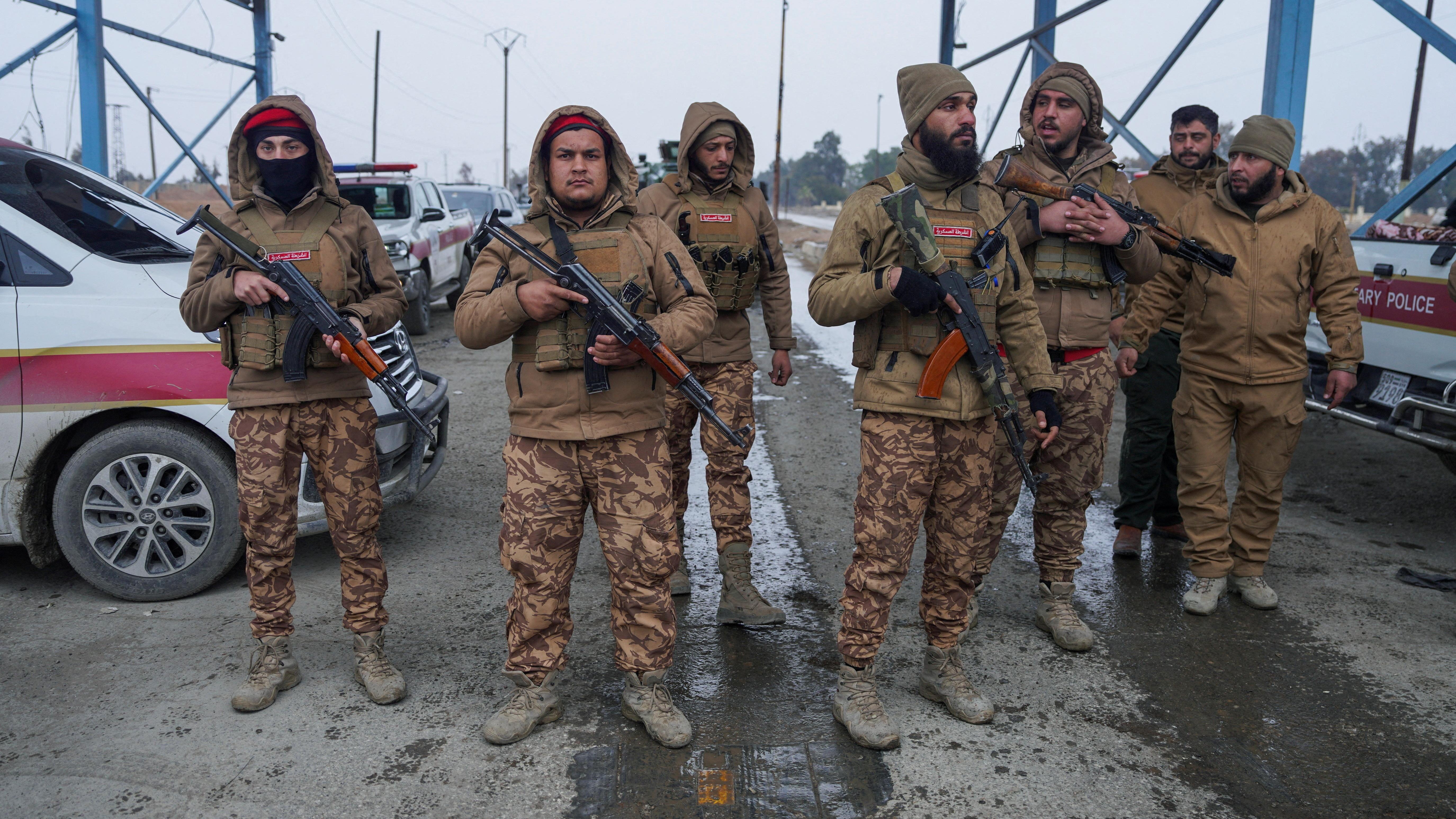 عناصر من الشرطة العسكرية السورية يتجمعون خارج سجن الأقطان، حيث يُحتجز بعض سجناء تنظيم الدولة الإسلامية، في الرقة، سوريا، 22 يناير/كانون الثاني 2026.