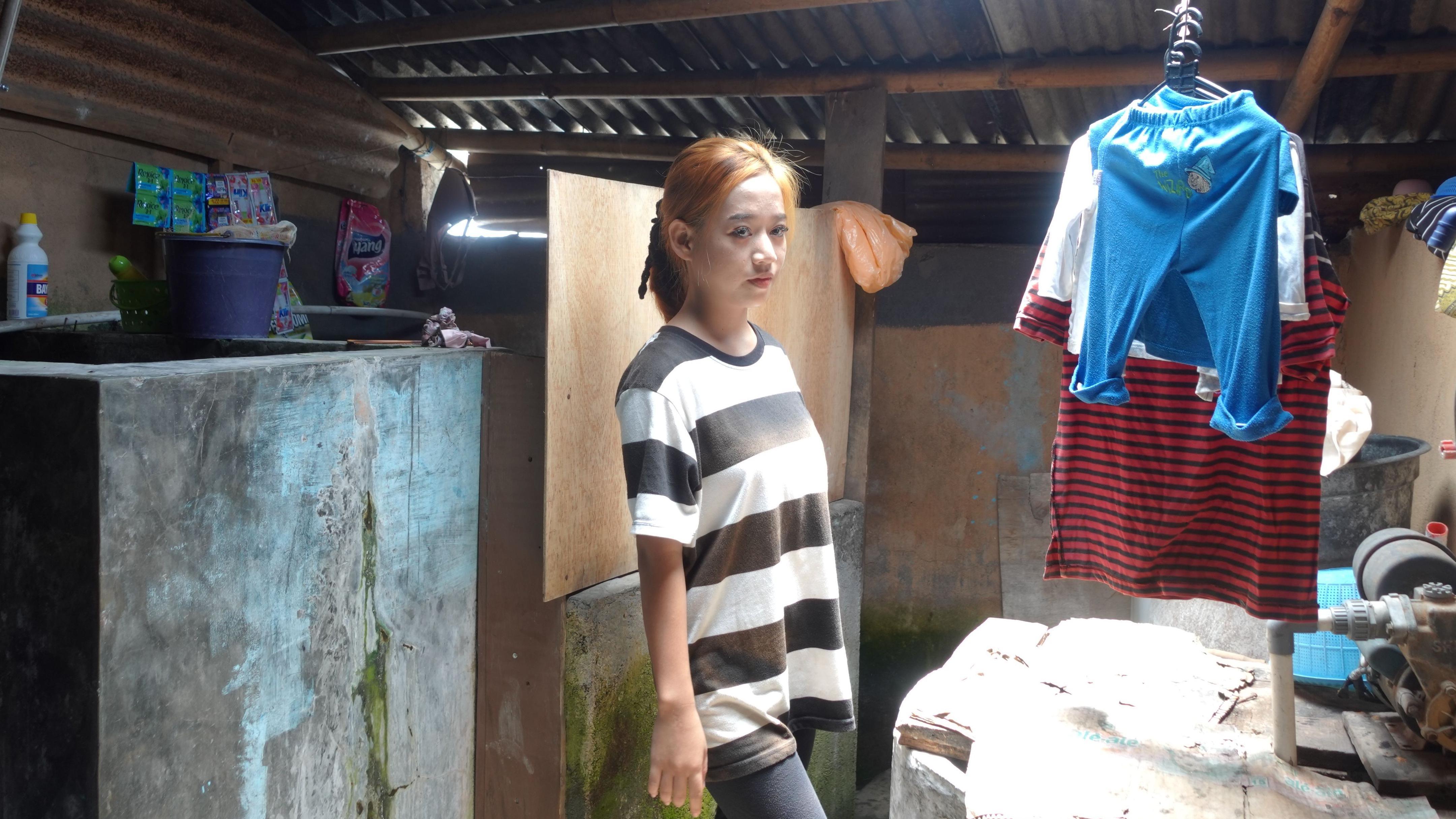Esti Agustina con una camiseta y pantalones en lo que parece ser un baño exterior
