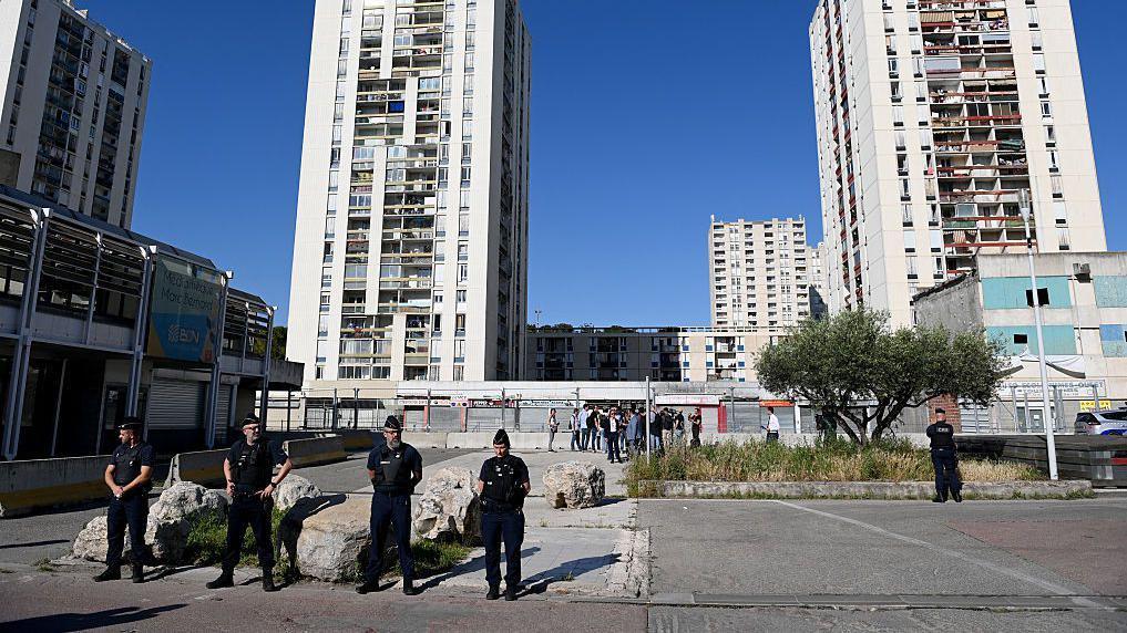 Varios policías frente a unos bloques de edificios.