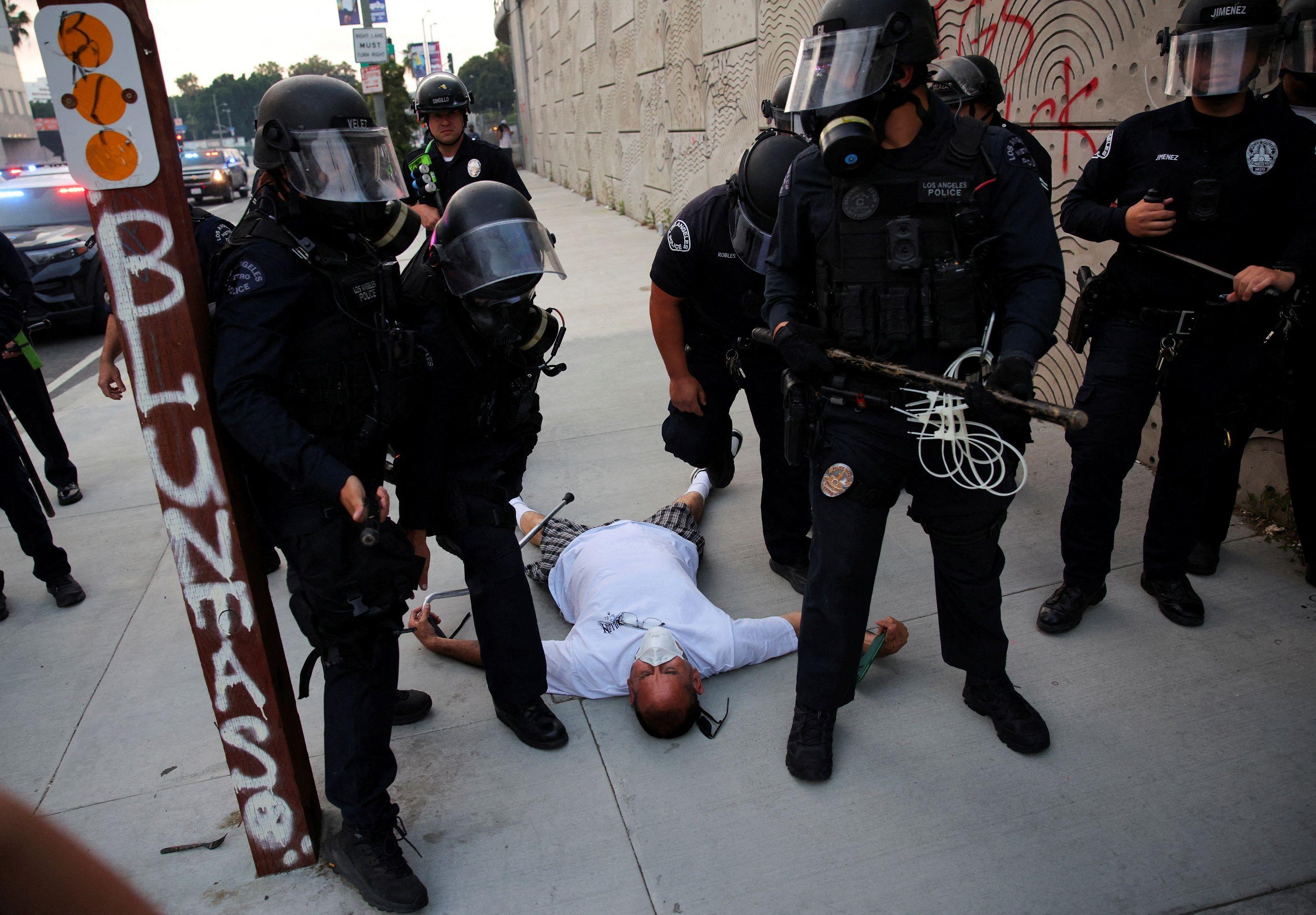 Personas permanece en el suelo rodeado de agentes de seguridad en el centro de Los Angeles