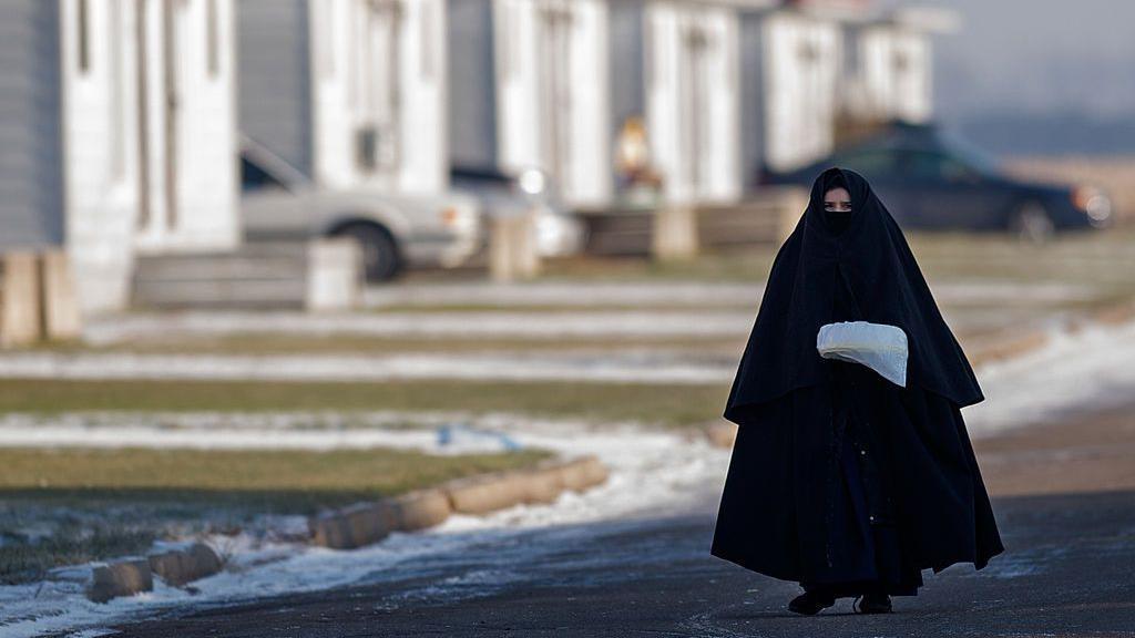 Una mujer miembro del grupo Lev Tahor camina con su vestimenta tradicional por las calles de Ontario. 