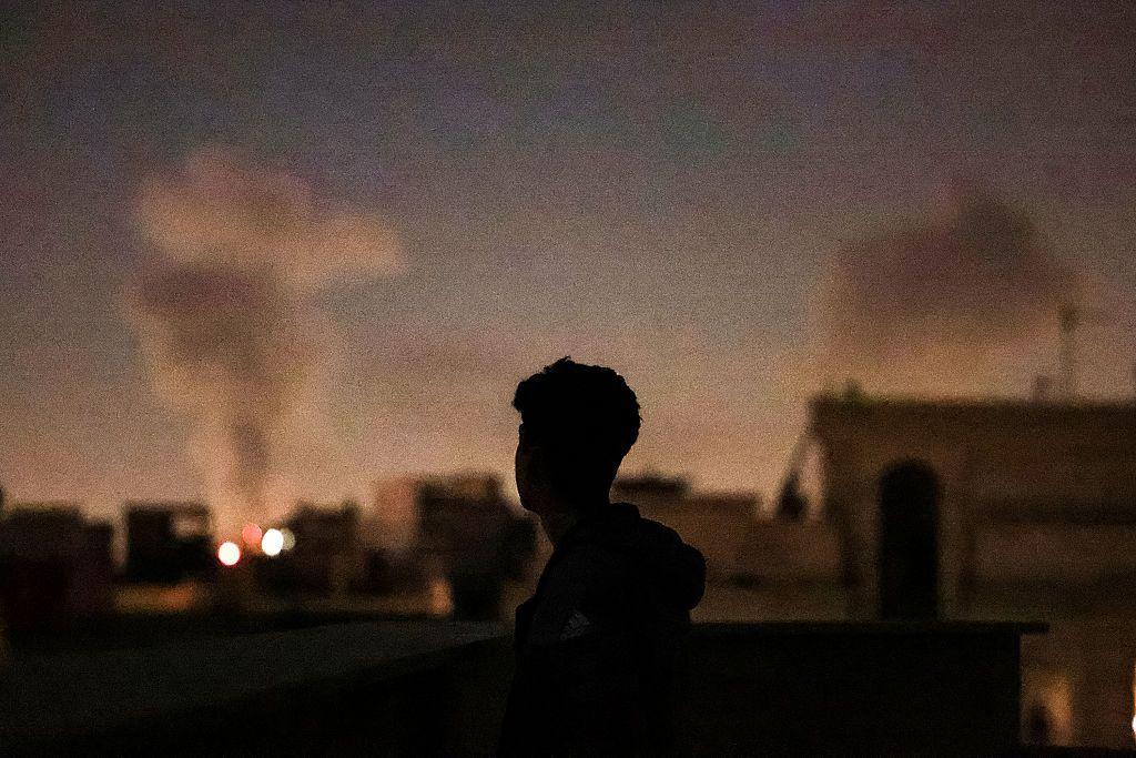 Hombre mira un bombardeo en Irán. 