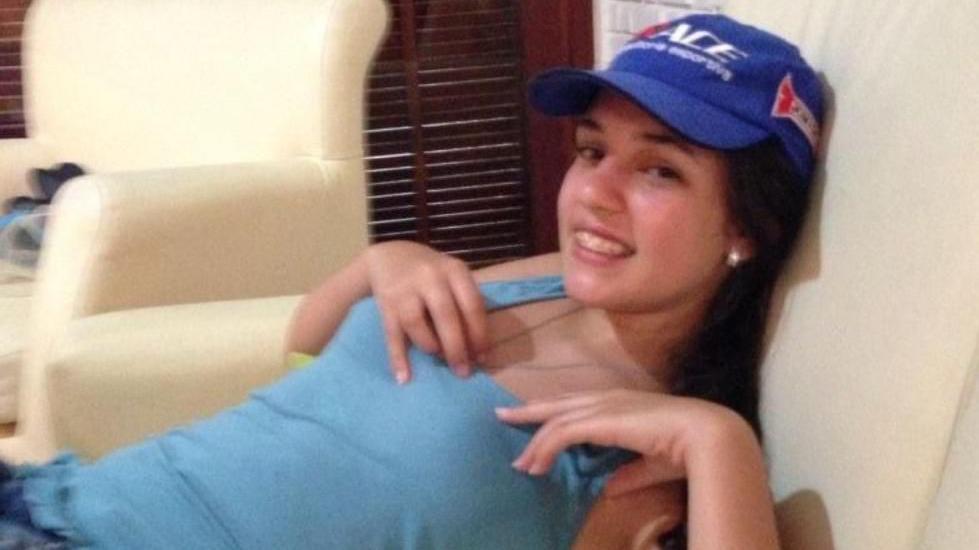 Victoria lleva una blusa azul y una gorra de béisbol.