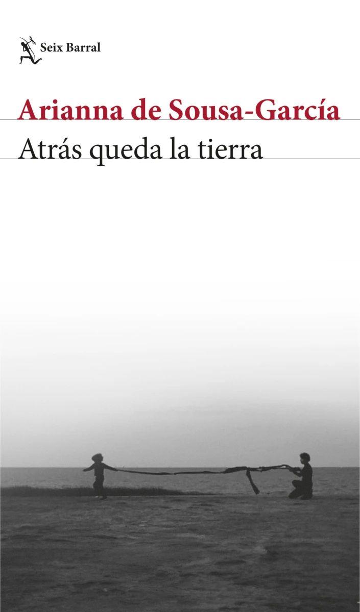 Portada del libro “Atrás queda la tierra” de Arianna de Sousa‑García, sobre una fotografía en blanco y negro de dos personas sosteniendo una larga tela frente a un paisaje abierto.