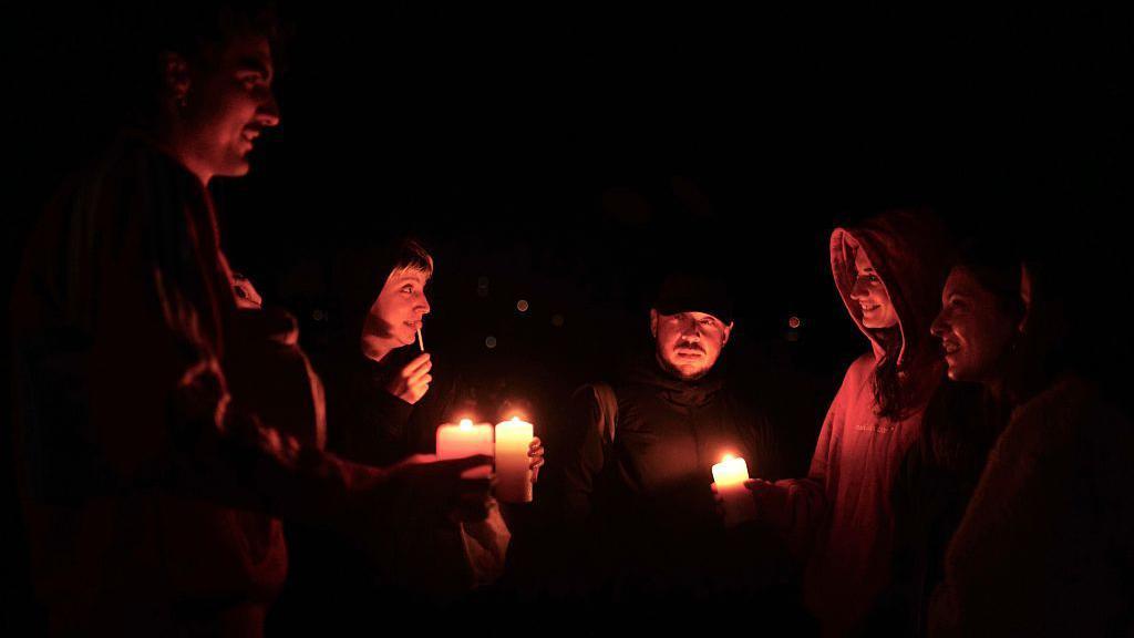 Unos amigos se reunen en torno a unas velas.