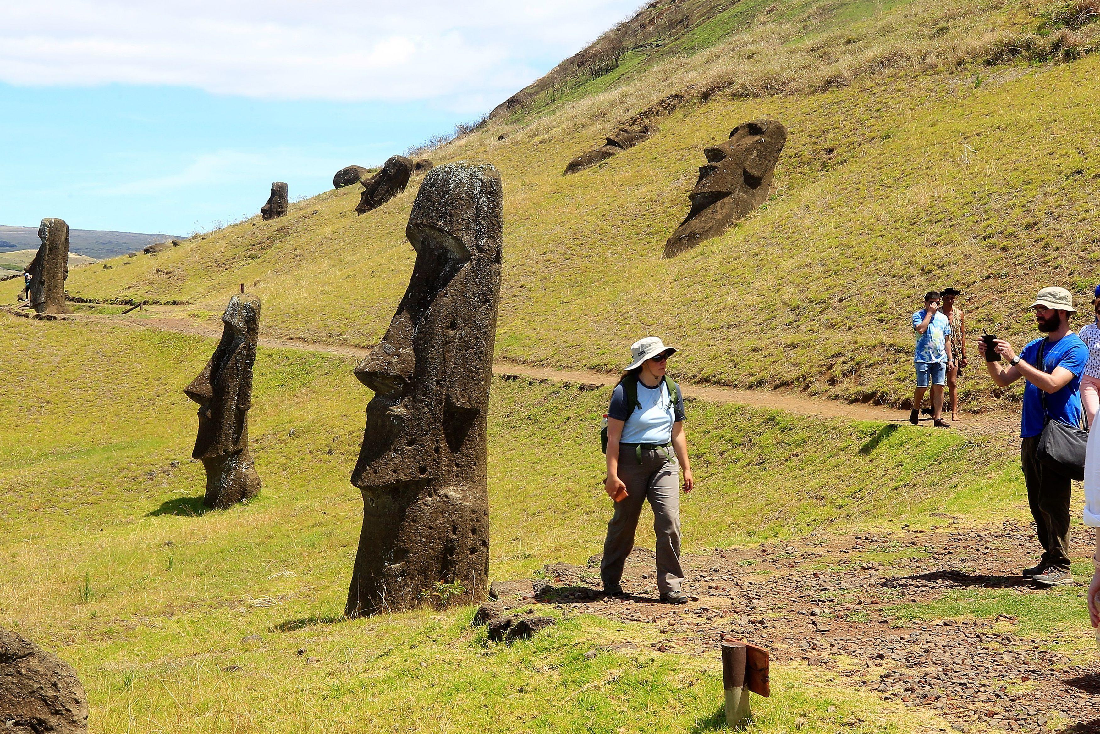 Turistas em meio a estátuas na Ilha de Páscoa