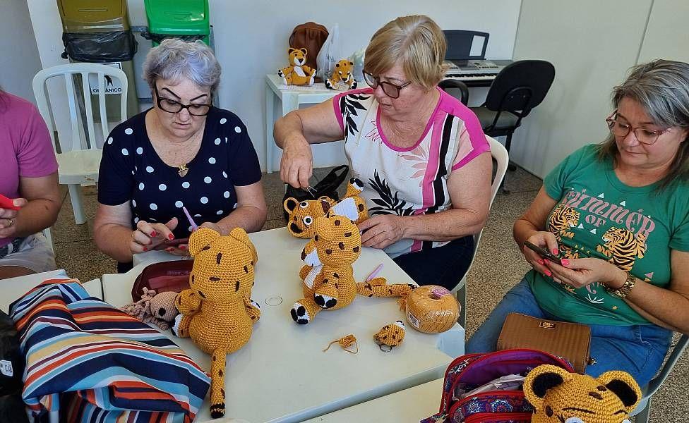 Mujeres tejiendo muñecos de jaguar en crochet