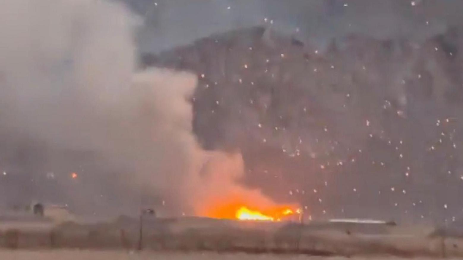 Iranian city 'hit hard' by strikes, say residents, while video shows huge blasts at missile base