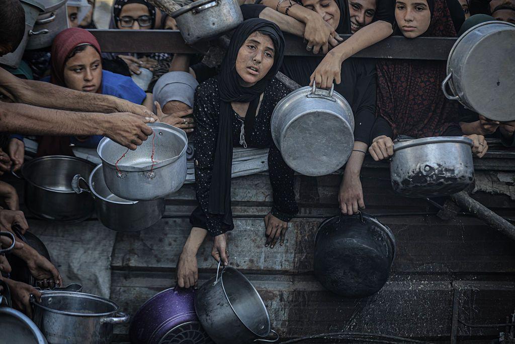 Un grupo de mujeres palestinas esperan agolpadas en Gaza a que les entreguen ayuda humanitaria.