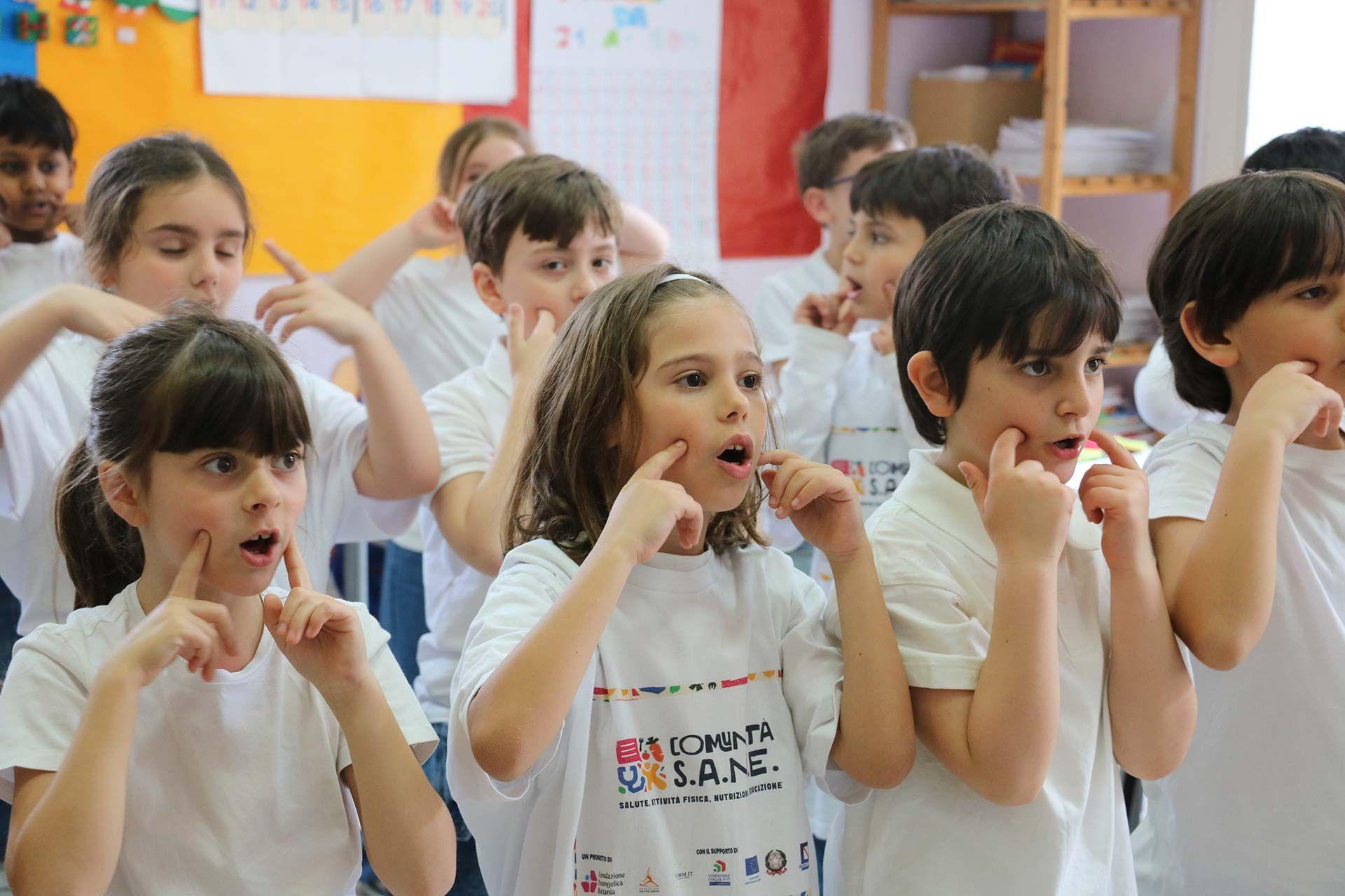 Crian&ccedil;as do ensino fundamental fazem o gesto italiano que indica que a comida est&aacute; gostosa