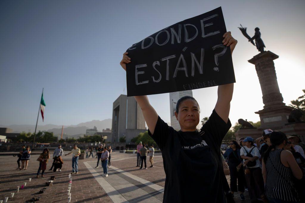 Una mujer sostiene un cartel en el que se lee: ¿Dónde están?