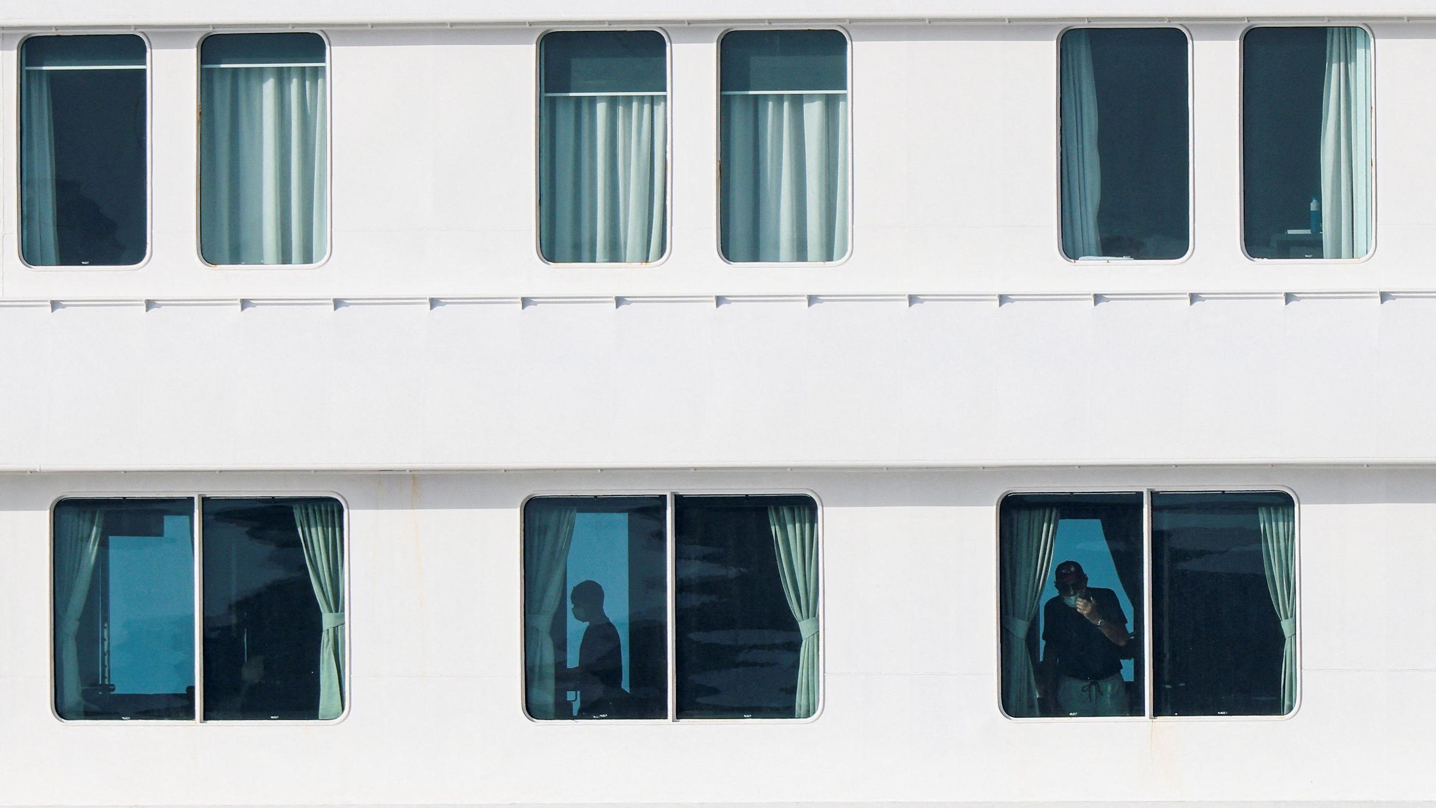The windows of the cruise ship show its crew members before the evacuation.
