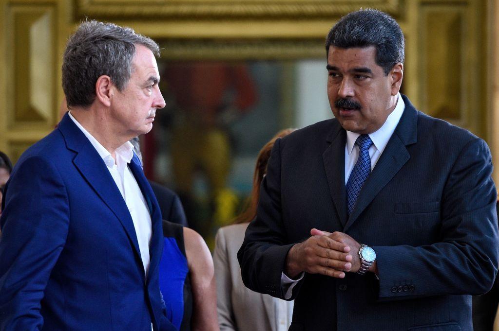 El presidente venezolano Nicolás Maduro (derecha) conversa con el expresidente del gobierno español José Luis Rodríguez Zapatero (izquierda) en el Palacio Presidencial de Miraflores, ambos vestidos de traje, Zapatero sin corbata. 