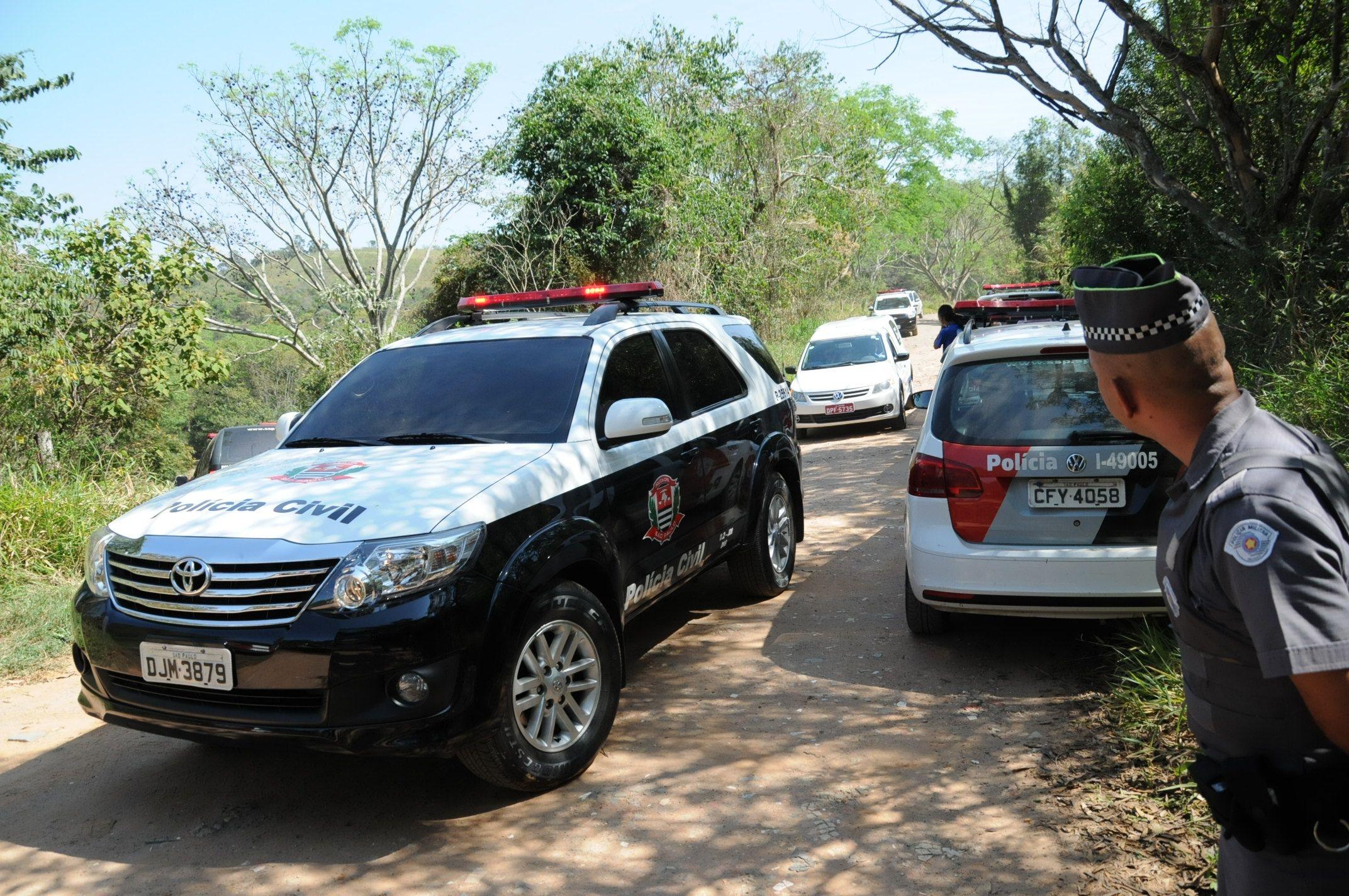 Carros da pol&iacute;cia em fazenda