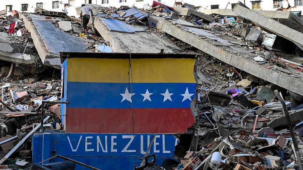 Edificio destruido en Caraballeda, La Guaira. En el primer plano una muralla destruida que dice Venezuela.