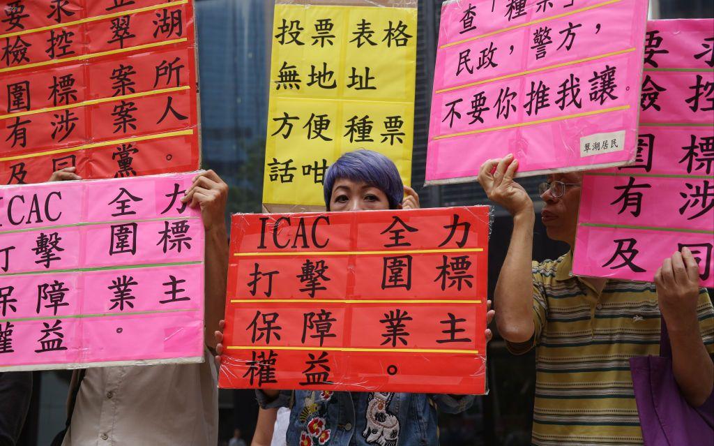 2016年9月29日，「全港業主反貪腐反圍標大聯盟」到灣仔的法院外抗議。一名業主手上持有「ICAC 全力打擊圍標 保障業主權益」的標語。