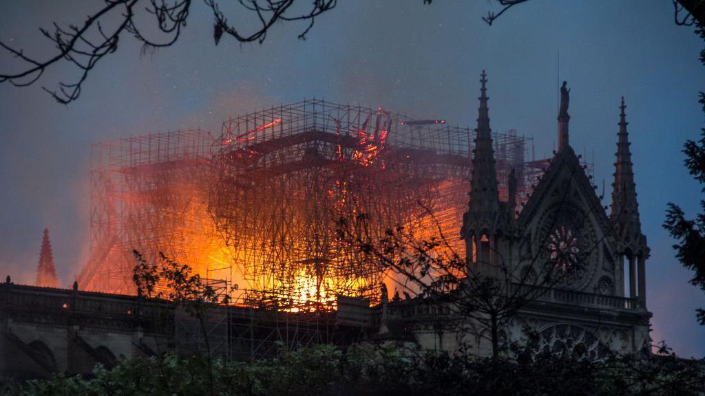 2019年4月15日，法國巴黎聖母院的屋頂冒出熊熊火焰和滾滾濃煙。