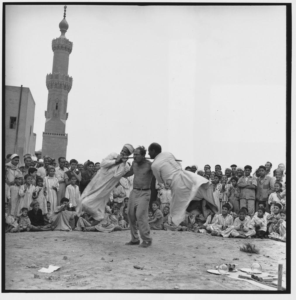 رجل قوي يستعرض قوته أمام حشد من المتفرجين خلال احتفالات ذكرى المولد النبوي الشريف في مصر عام 1966.