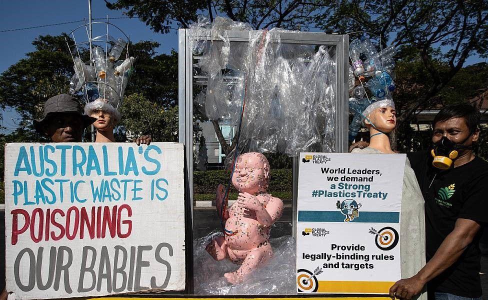 Activistas de Indoenesia protestas contra el plástico procedentes de Australia. Muestran un muñeco que representa a un bebé y un cartel que dice "La basura plástica de Australia está envenenando a nuestres bebés"