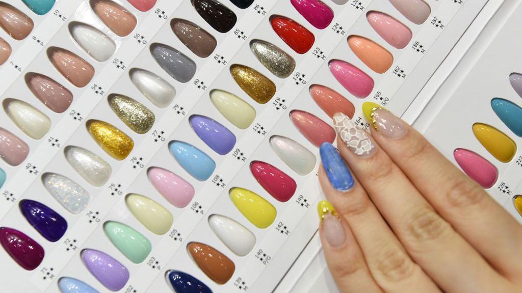 خبيرة أظافر تفحص عينات ألوان من جل الأظافر خلال منتدى طوكيو للأظافر في طوكيو في 16 مايو/ أيار 2017. 